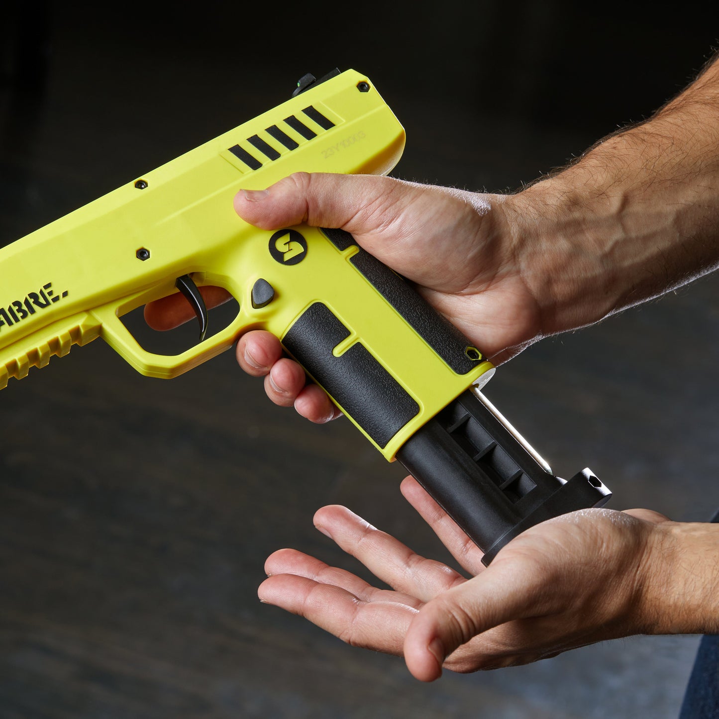 Someone loading 0.68 Caliber Home Defense Pepper Projectile Launcher – .68 caliber personal defense launcher designed for home use, featuring a ready-to-fire CO₂-powered firing mechanism that launches irritant pepper projectiles at defensive range, in gray background.