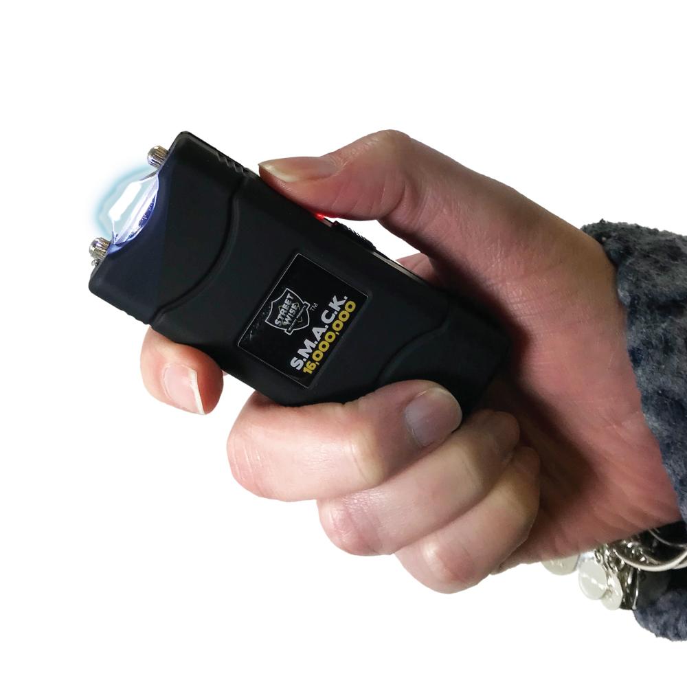 Someone holding SMACK 16,000,000 Stun Gun - ultra-compact and powerful self-defense device designed to fit on a keychain for convenient everyday carry, in white background.