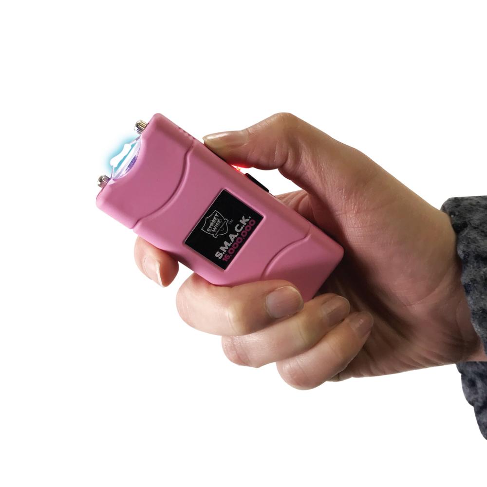 Someone holding SMACK 16,000,000 Stun Gun - ultra-compact and powerful self-defense device designed to fit on a keychain for convenient everyday carry, in white background.