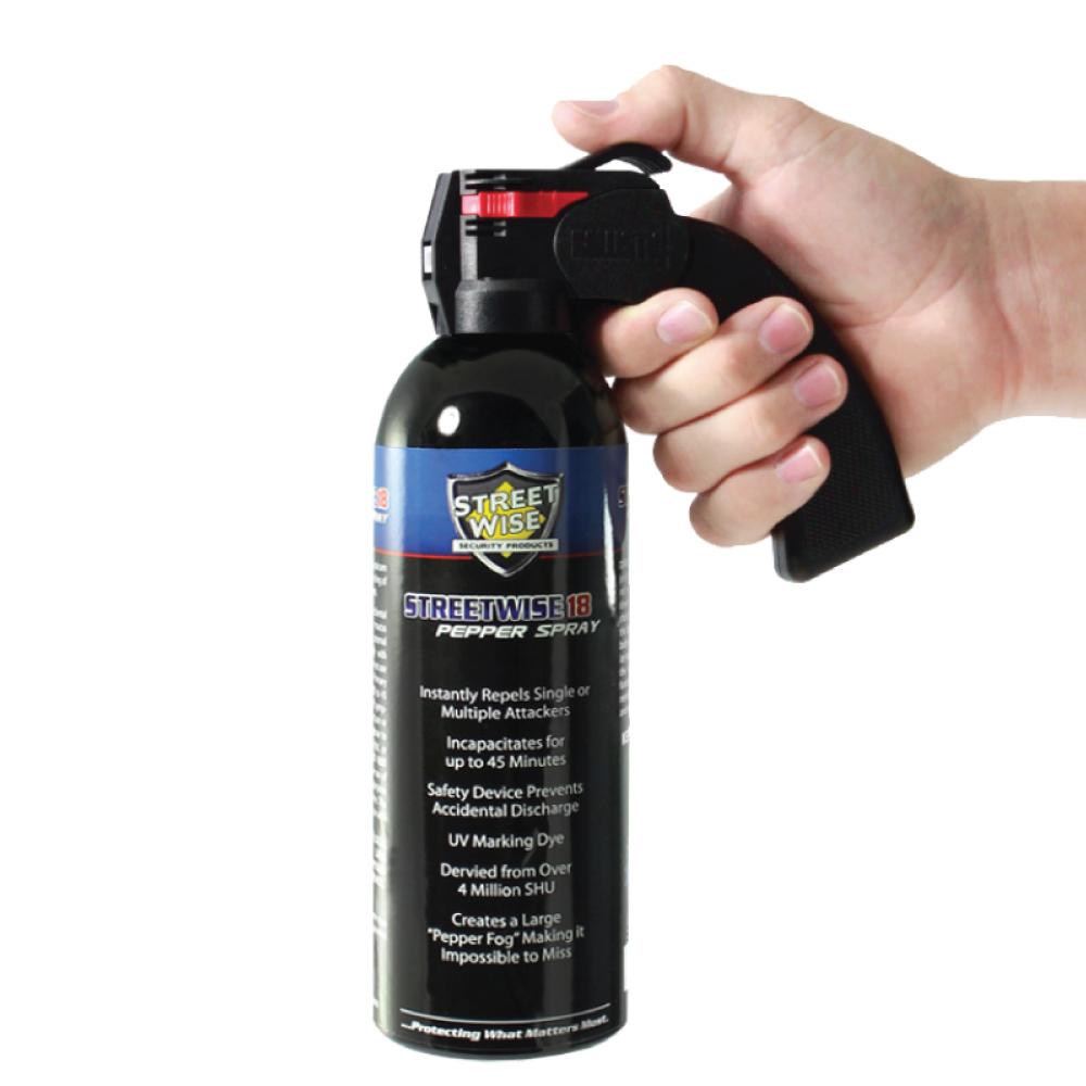 Someone holding Streetwise 18 Pepper Spray 16 oz Pistol Grip for wide-area self-defense on white background.
