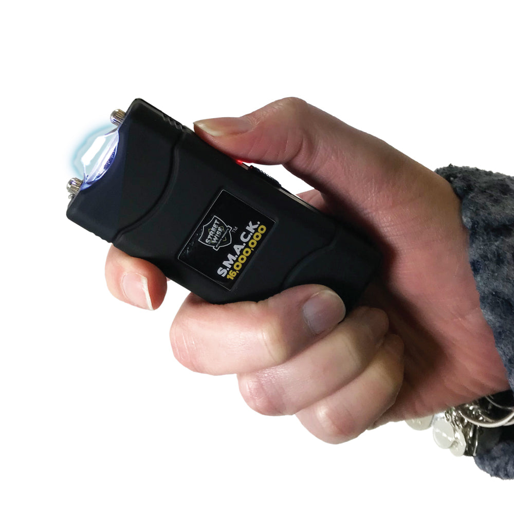 Someone holding Streetwise Self‑Defense Keychain Combo – compact personal safety tool that combines a loud 130 dB alarm, LED flashlight, and shock delivery device on a keychain, designed for convenient everyday carry and quick access in emergencies, in white background.