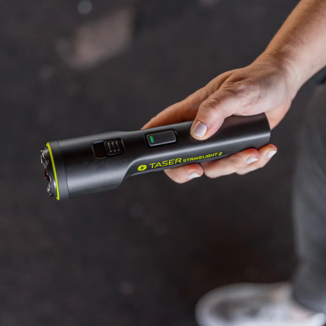 Someone holding TASER StrikeLight 2 Kit – versatile self-defense flashlight featuring a 700-lumen beam, built-in stun capability, audible arc warning, and USB-C charging for everyday protection.