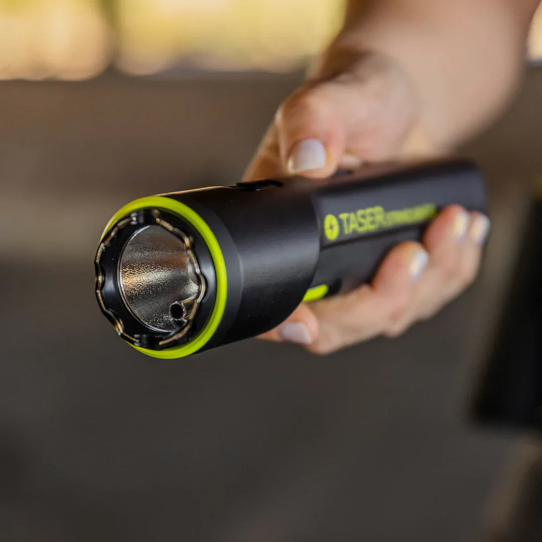 Someone holding TASER StrikeLight 2 Kit – versatile self-defense flashlight featuring a 700-lumen beam, built-in stun capability, audible arc warning, and USB-C charging for everyday protection.