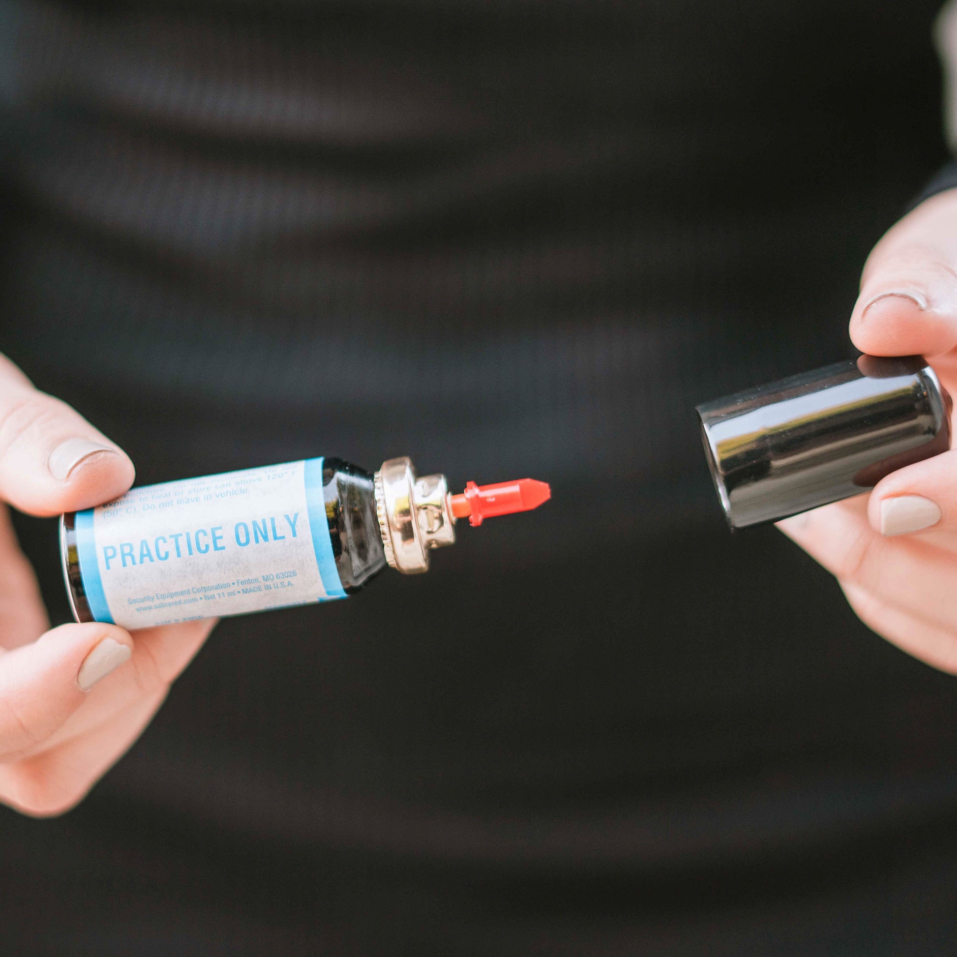 Someone opening cartridge of Aim and Fire Pepper Gel with Trigger and Grip Deployment – pistol-style pepper gel launcher featuring a 15-foot range, 13 bursts per cartridge, and a grip safety to prevent accidental discharge.