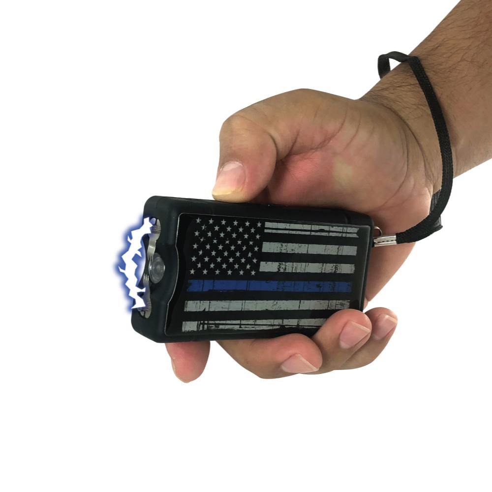 Someone holding Blue Line 9,000,000 Stun Gun - compact and reliable self-defense tool featuring a high-voltage charge and a design honoring law enforcement support, in white background.