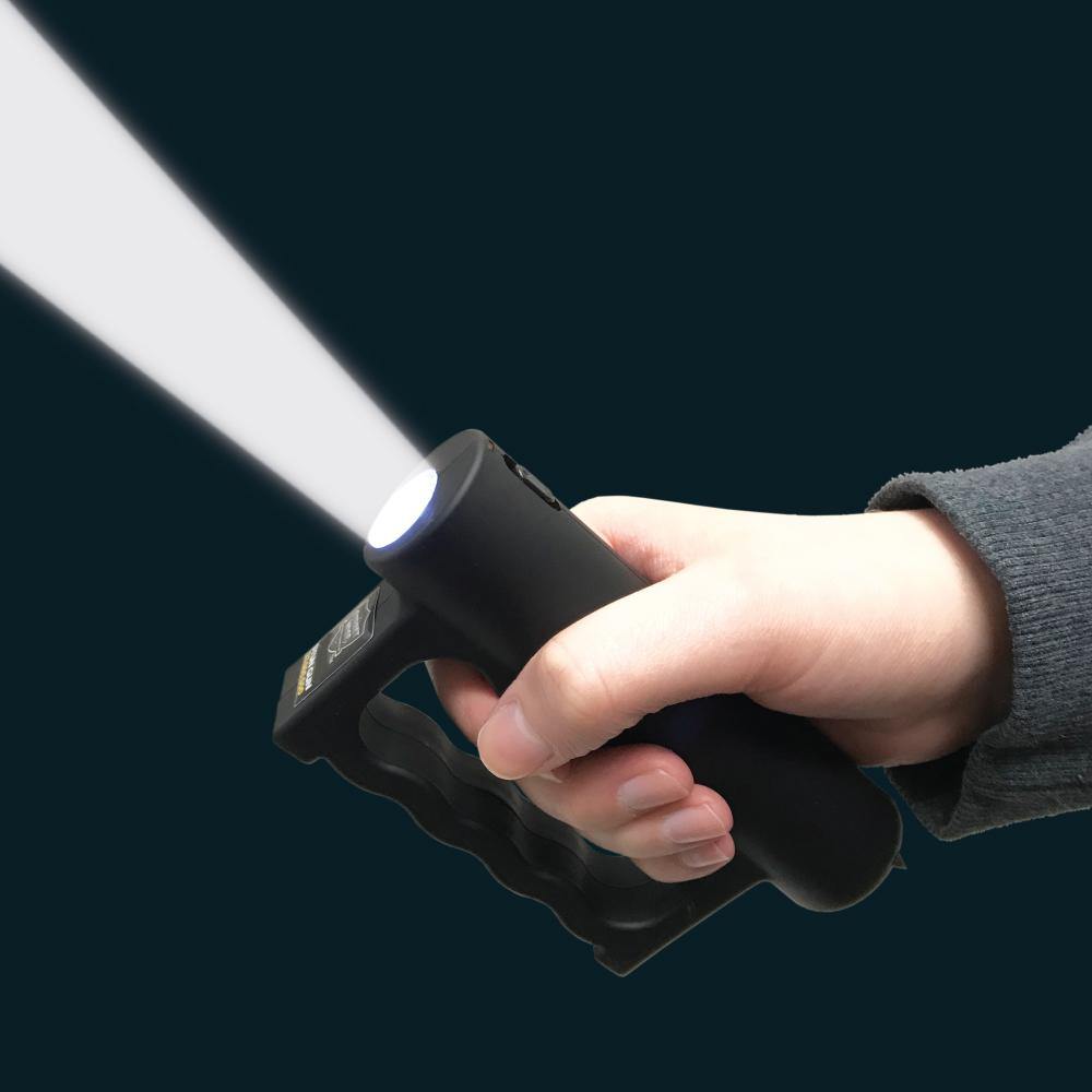 Someone holding Double Down 23,000,000* Stun Gun - powerful dual-contact stun device designed for maximum stopping power and reliable personal protection, in dark background.