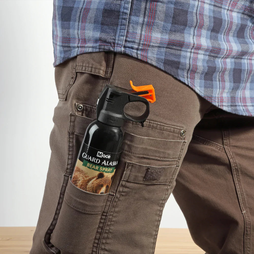 Close-up of someone carrying a Guard Alaska 9oz Firemaster Fogger pepper spray canister with high-capacity nozzle for wide-area animal defense.