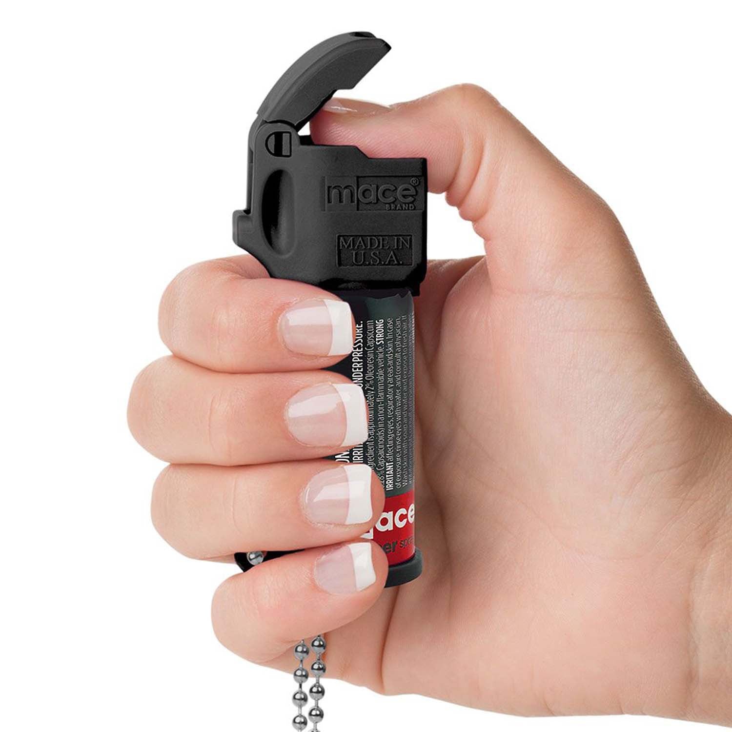 Someone holding Mace Pocket Model Stream Pepper Spray – compact self-defense spray with a focused stream pattern delivering up to 10 ft of range, flip-top safety cap, finger-grip design, and UV dye for attacker identification, in white background.