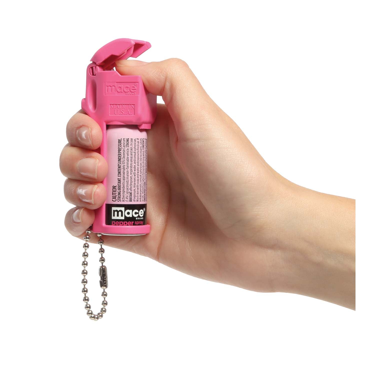 Someone holding Mace Pocket Model Stream Pepper Spray – compact self-defense spray with a focused stream pattern delivering up to 10 ft of range, flip-top safety cap, finger-grip design, and UV dye for attacker identification, in white background.