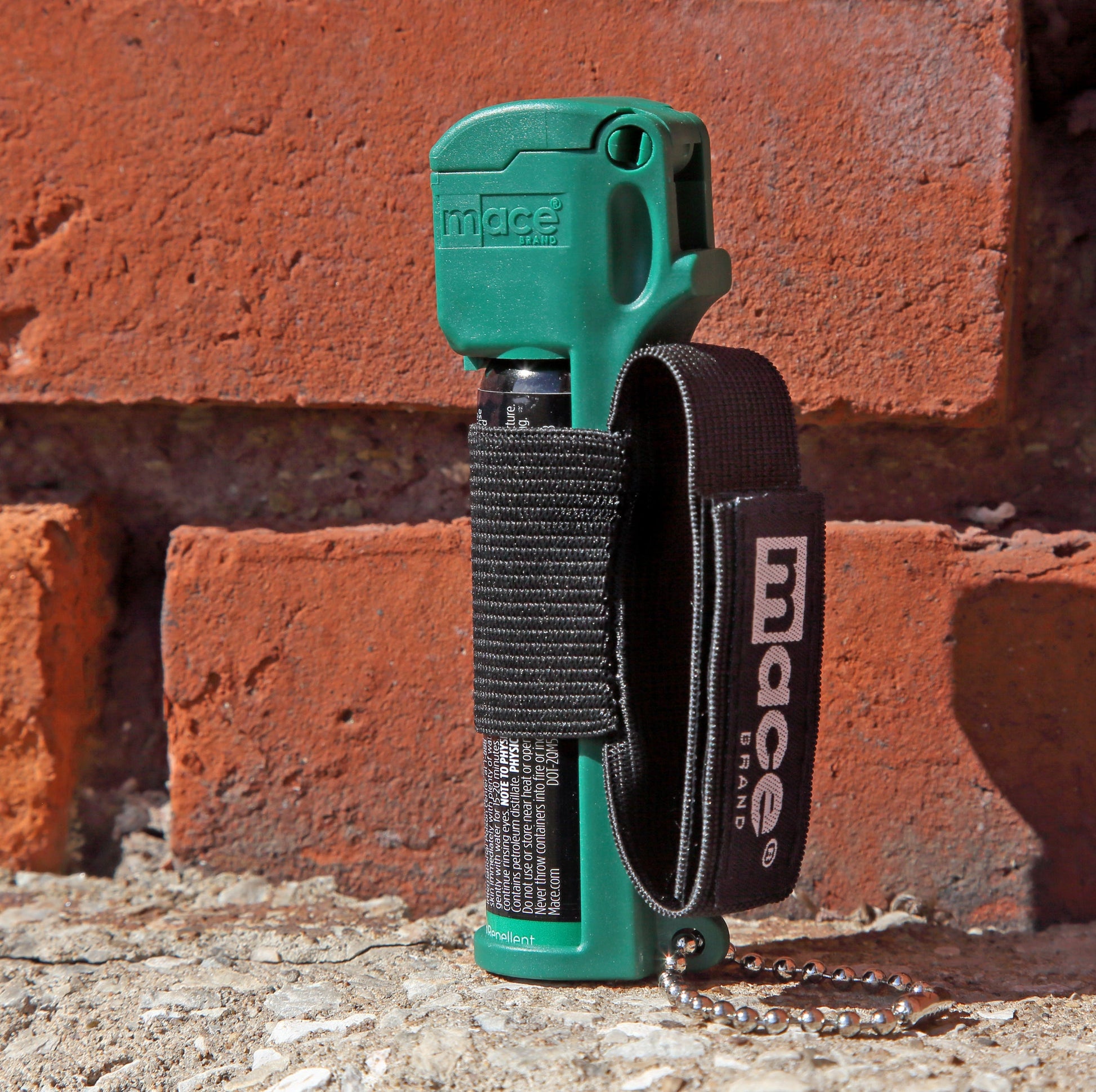 Muzzle Dog Repellent Pepper Spray – compact, canine-safe pepper spray with a stream delivery system reaching up to 10 ft, flip-top safety cap, finger-grip design, keychain attachment, and adjustable strap for hands-free use during walks or jogging, in brick background.