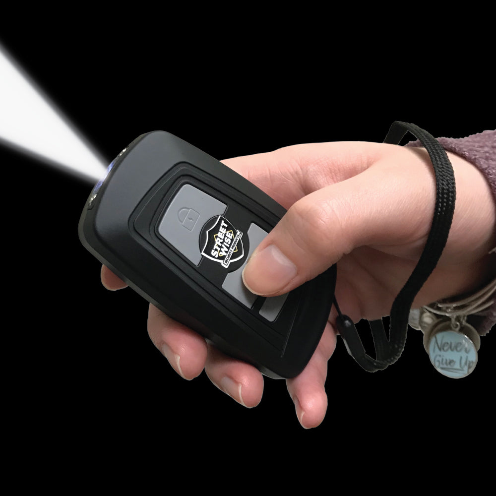 Someone holding Razoer 23,000,000 Stun Gun - sleek and powerful self-defense tool with a slim design, combining high voltage output with easy protability, in black background.