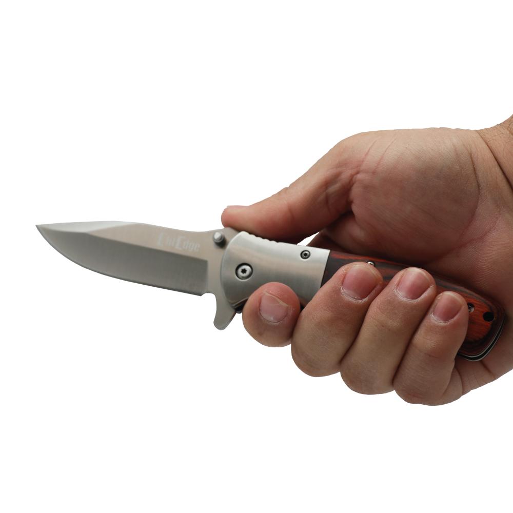 Someone holding Woodgrain 8-inch premium folding knife with textured handle, ideal for collectors and outdoor use.