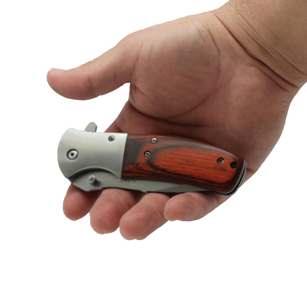 Someone holding Woodgrain 8-inch premium folding knife with textured handle, ideal for collectors and outdoor use.